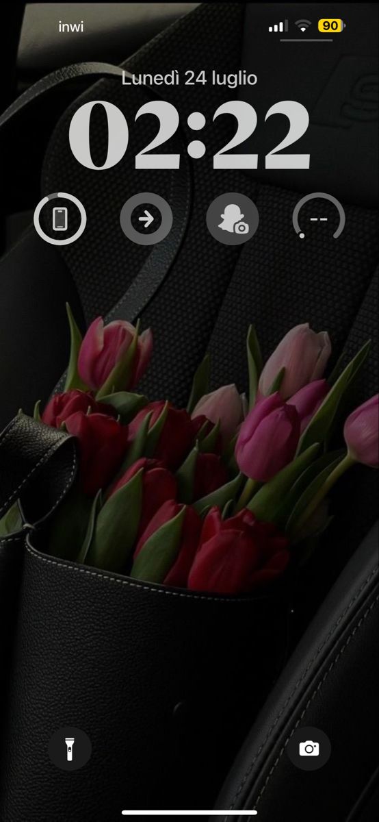 a bunch of flowers sitting inside of a car seat next to a clock on the dashboard