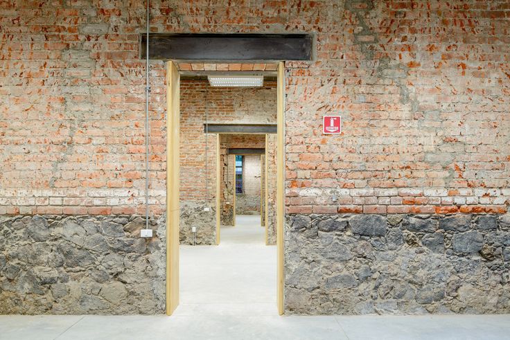 an open door leading to another room with brick walls and doors on both sides,