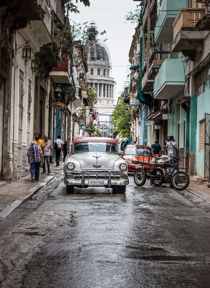 an old car is parked on the street