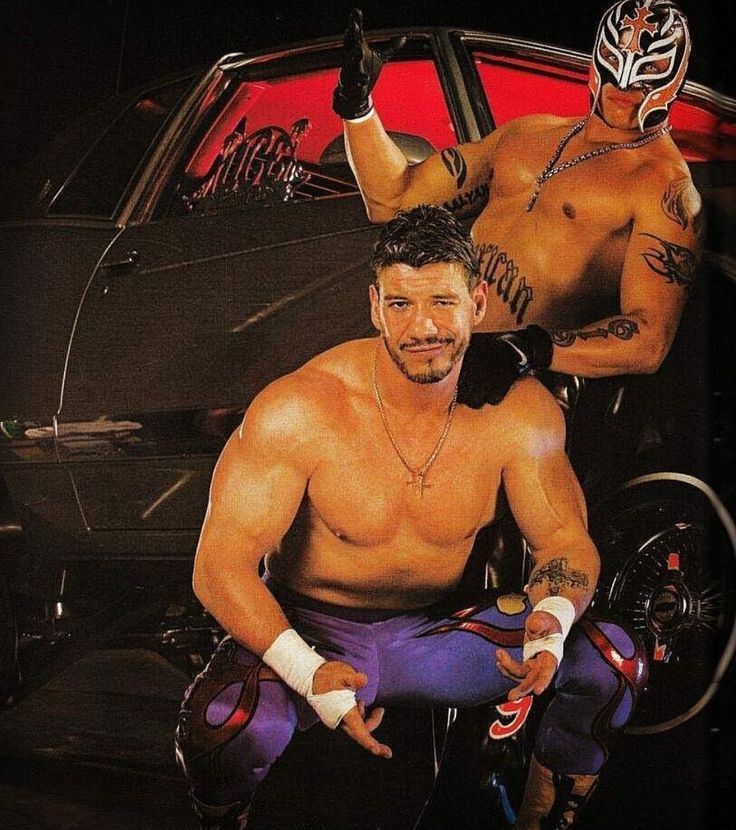 two men in wrestling gear sitting next to each other with their hands on their hipss