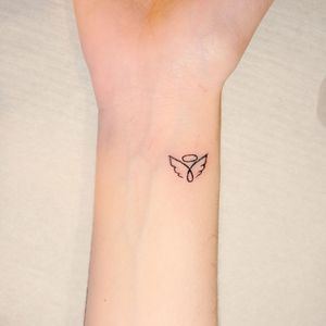 a woman's wrist with a small tattoo on the left side of her arm