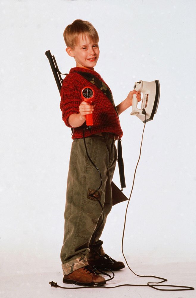 a young boy holding a video game controller in one hand and a wii mote in the other