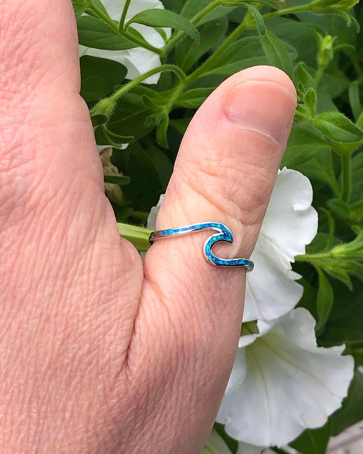 Sterling Silver Wave Ring with Blue Lab Opal | The Life Divine Keep the ocean close and go with the flow. This sterling silver Wave Ring symbolizes the ups and downs we see in life, reminding you to roll with the tides. Wear this ring as a reminder to stay positive, happy and strong regardless of what life throws your way.Cherished for its brilliance, Opal is known as a stone of creativity and vitality. Opal is also a reflective stone of protection, absorbing energies and sending them back to th Handmade Blue Ring For Summer, Ocean-inspired Blue Ring For Gift, Ocean-inspired Blue Ring For Gifts, Ocean-inspired Blue Rings As Gifts, Minimalist Blue Jewelry For Beach, Minimalist Nickel-free Blue Ring, Go With The Flow, Wave Ring, Stay Positive