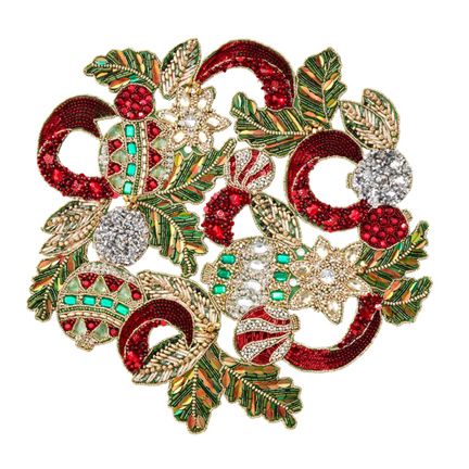 a red and green brooch with lots of jewels in it's center, on a white background