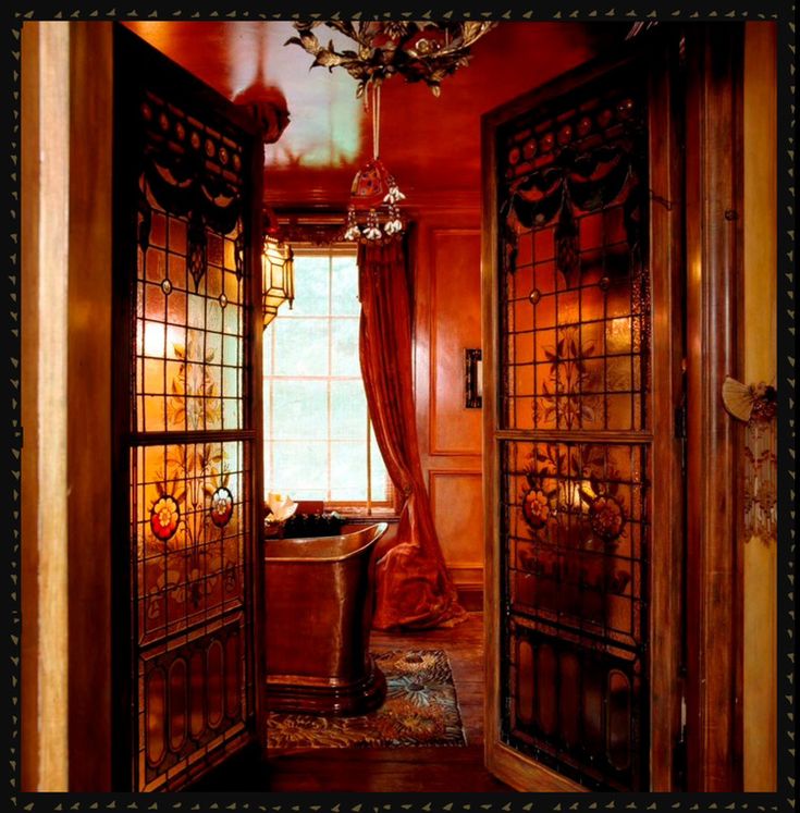 an open door leading to a bathroom with a chandelier hanging from the ceiling