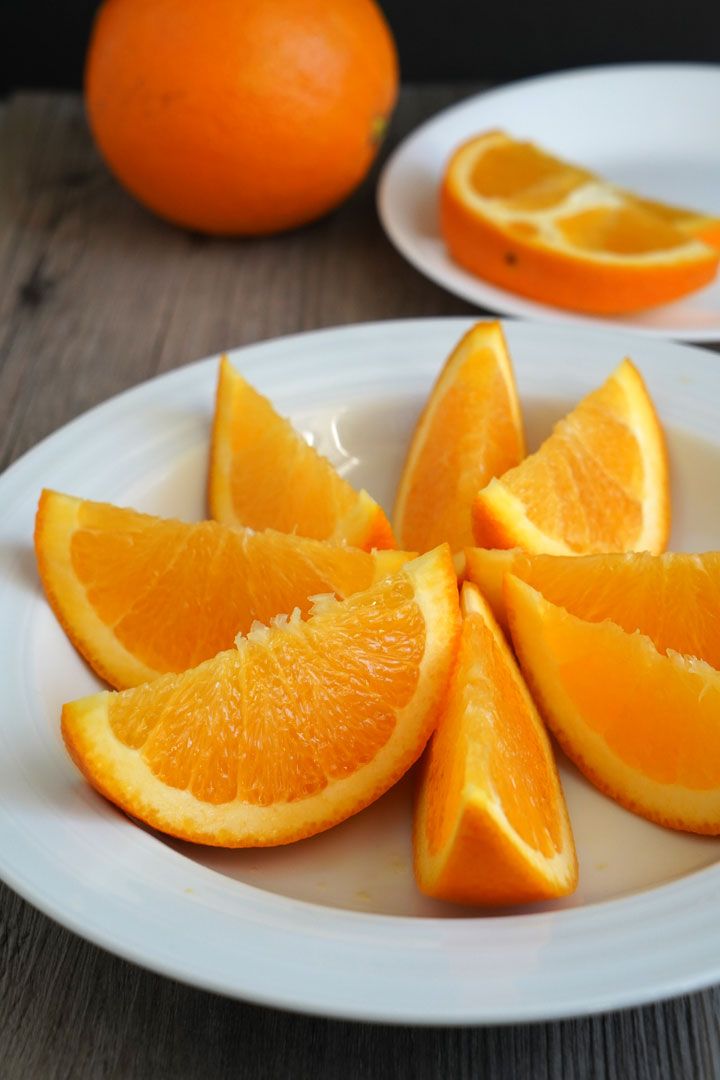 sliced oranges sitting on top of a white plate