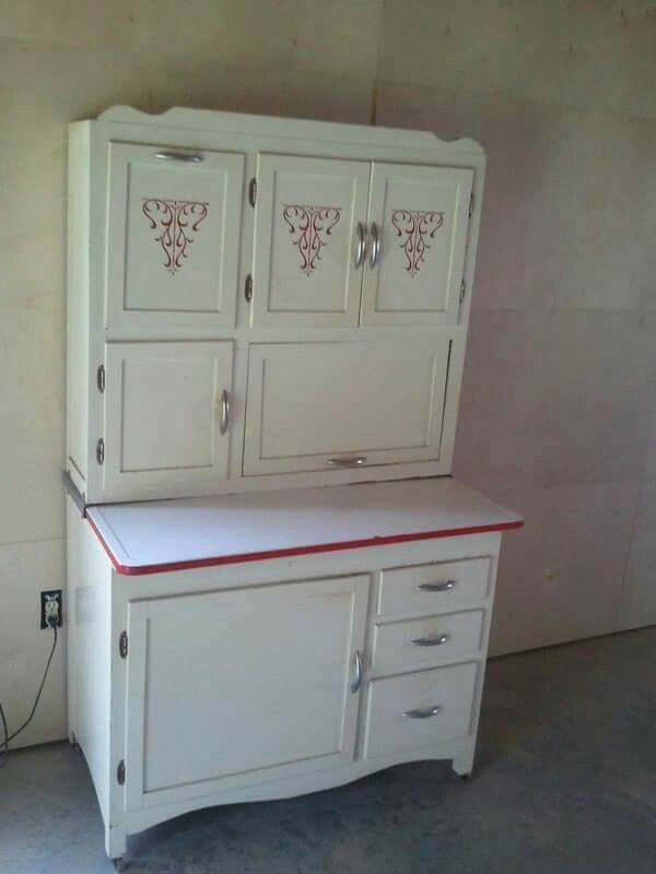 a white cabinet with red trim and drawers