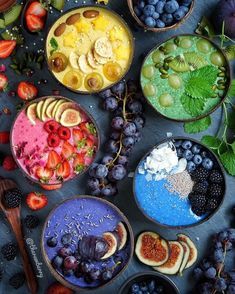 bowls filled with different types of fruits and berries on top of a blue table cloth