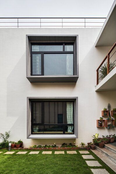 an apartment building with two balconies on the second floor and grass in front