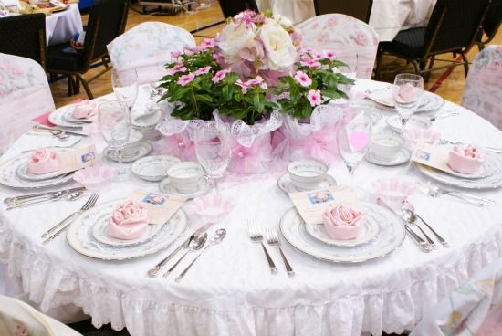 the table is set with pink and white decorations