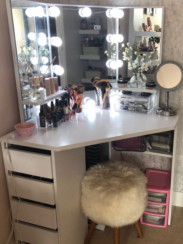 a vanity with lights on and a stool