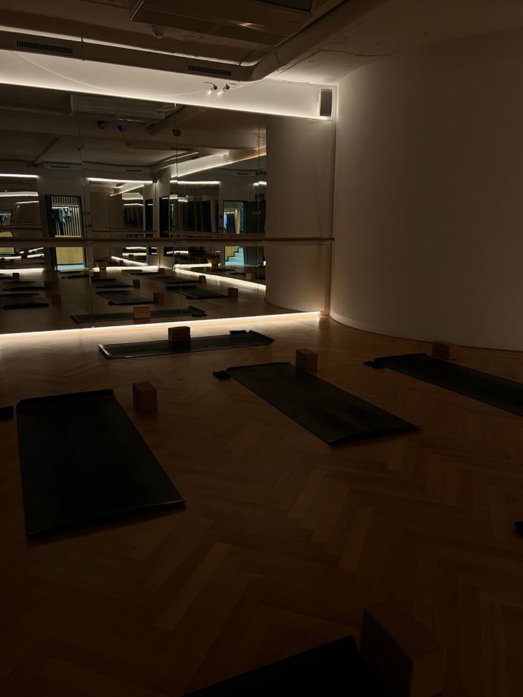 there are many yoga mats on the floor in this large room that is lit up