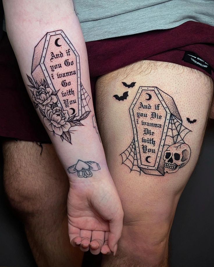 two people with tattoos on their legs holding hands and one has a tombstone in it