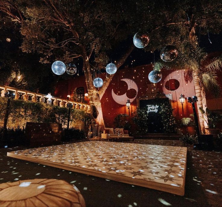 the dance floor is lit up at night with lights and decorations hanging from it's ceiling