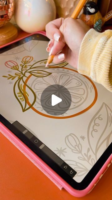 a child's hand holding a pencil and drawing on an ipad with the screen open