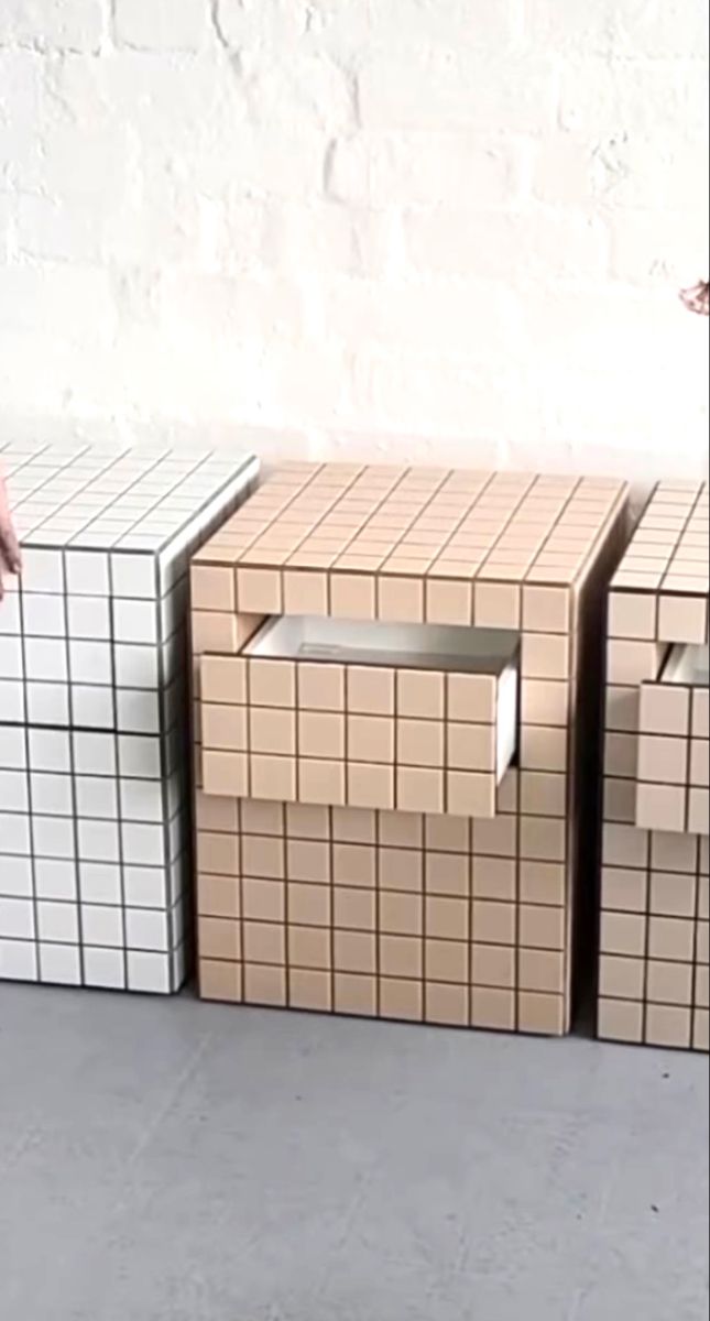 a person standing in front of three boxes on the floor with one hand reaching for it