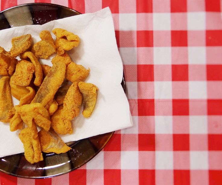 a plate full of fried food on a red and white checkered table cloth