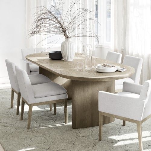 a dining room table with white chairs around it