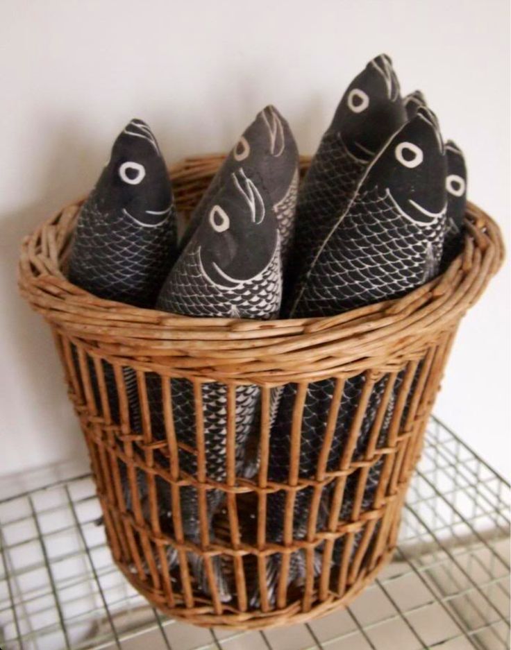 four black fish napkins sitting in a basket on a shelf next to a wire rack