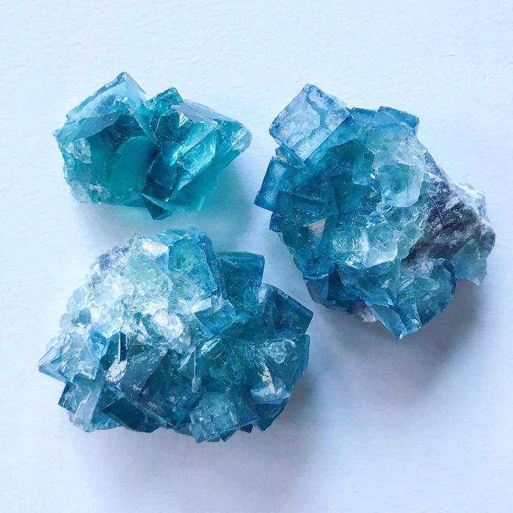 three pieces of blue glass sitting on top of a table