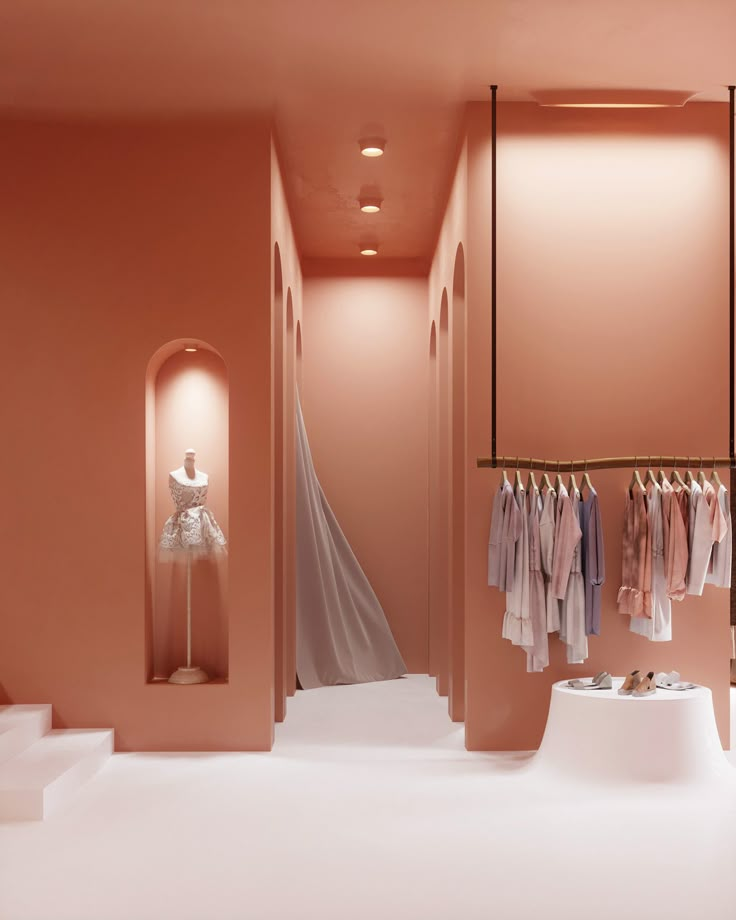 a pink room with clothes hanging on racks and an open door leading to the closet