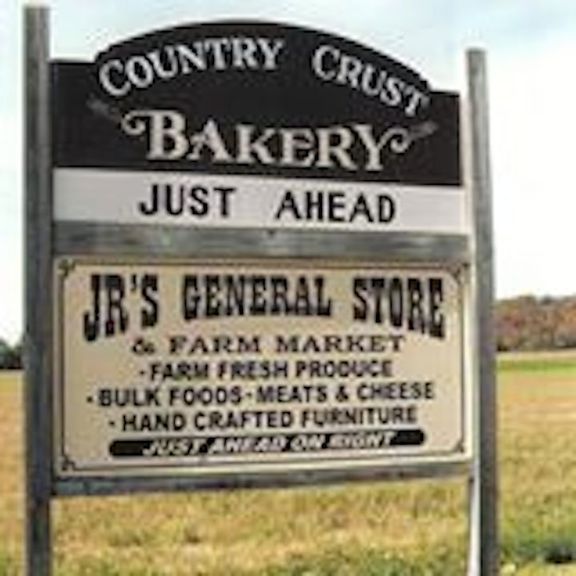 a sign that says country crust just ahead and it's general store in front of a field