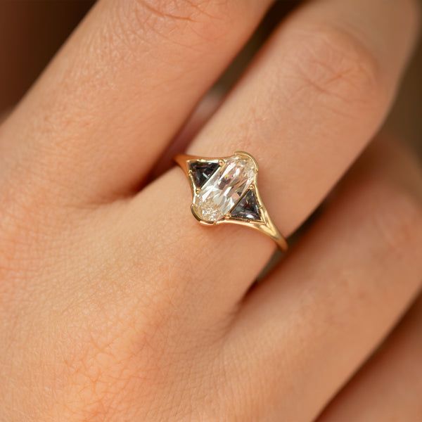 a woman's hand with a yellow and white diamond ring on top of her finger