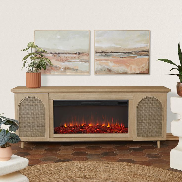 a living room with a fire place and two paintings on the wall