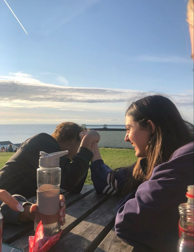 two people are sitting at a picnic table