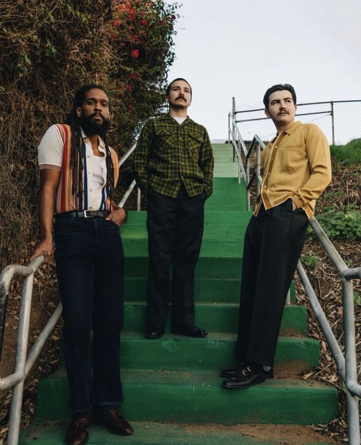 three men are standing on the stairs outside