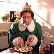 a man wearing a party hat and eating candy at a table in front of him