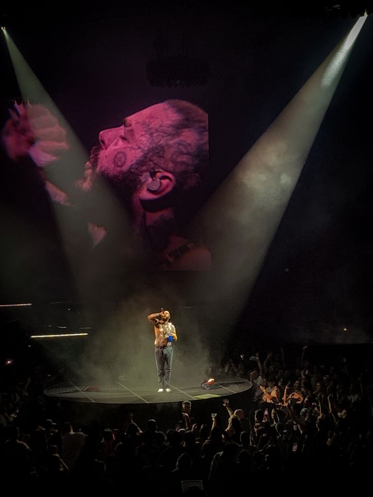 a man standing on top of a stage under spotlights