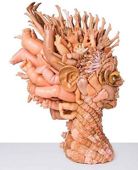 a sculpture of a human head made out of wood sticks and other things in it