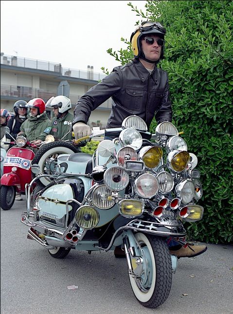 a man riding on the back of a motorcycle with lots of headlight's