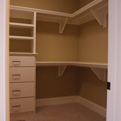 an empty walk in closet with drawers and shelves