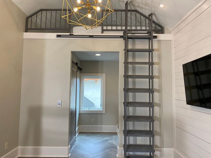 a room with a ladder and a tv mounted on the wall