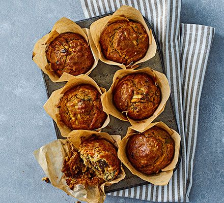 several muffins sitting on top of a baking pan next to a striped napkin