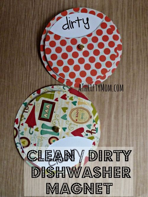 two dirty dishwasher magnets sitting on top of a wooden table