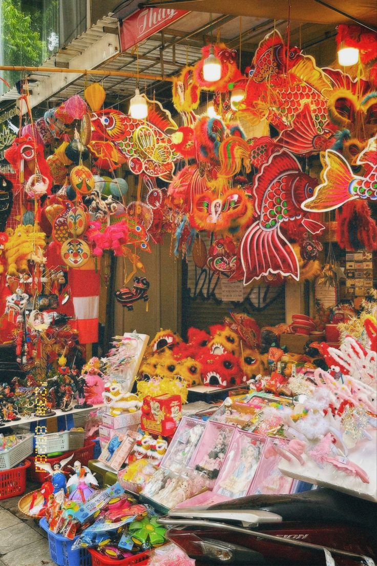 an outdoor market with lots of colorful decorations and lights hanging from it's ceiling