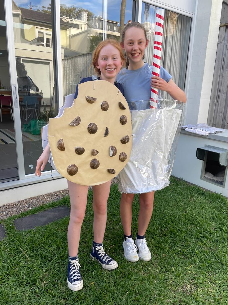 two girls are holding up a giant cookie