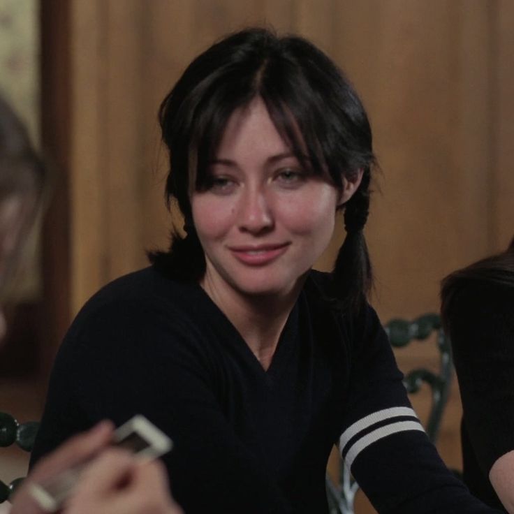 a woman sitting at a table with two other women