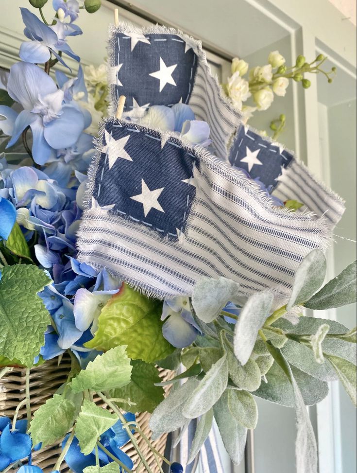 an american flag wreath with blue flowers and greenery