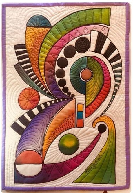 a quilted wall hanging with an abstract design