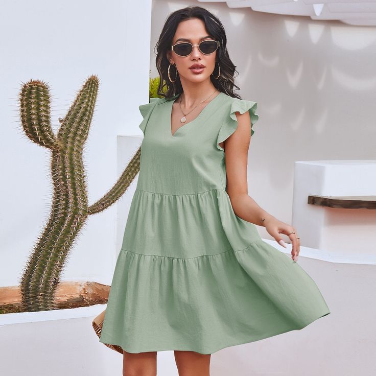 The EMES SHOP dress is detailed with gorgeous ruffle sleeves. Features a v neck line. shift dress silhouette. tiers. and an above knee length. Pair it with a hat and espadrilles for a refreshing summer look.MATERIAL:100% Soft Cotton MEASUREMENTS:Dress Length is 35-37"in Small | Bust & Waist: 37"-39"in Medium | Bust& Waist: 39"-41"in Large | Bust& Waist: 41"-43in V-neck Tiered Dress With Ruffle Hem For Beach, Casual V-neck Tiered Dress For Beach, Green Summer Tiered Dress, Green Tiered Ruffle Dress For Beach, Green Tiered Summer Dress With Ruffles, Summer Green Tiered Dress With Ruffles, Casual Mini Dress With Ruffle Hem For Summer, Bohemian Ruffled Tiered Summer Dress, Bohemian Summer Tiered Ruffle Dress