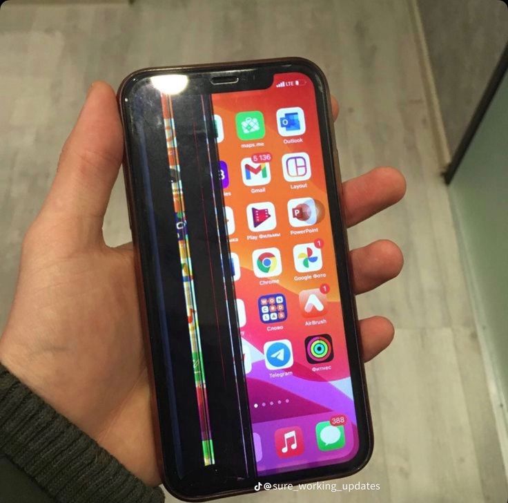 a person holding an iphone in their left hand with the screen partially open showing icons