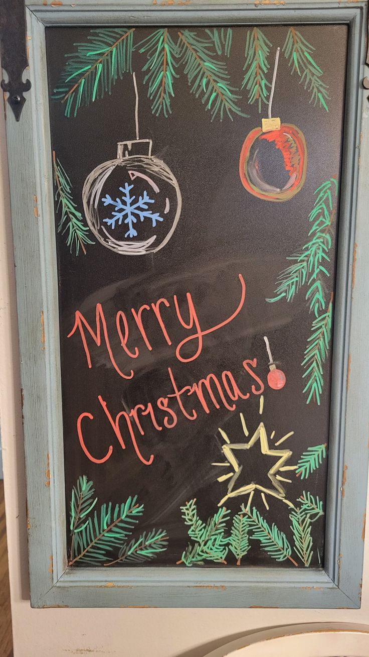 a chalk board with christmas decorations on it