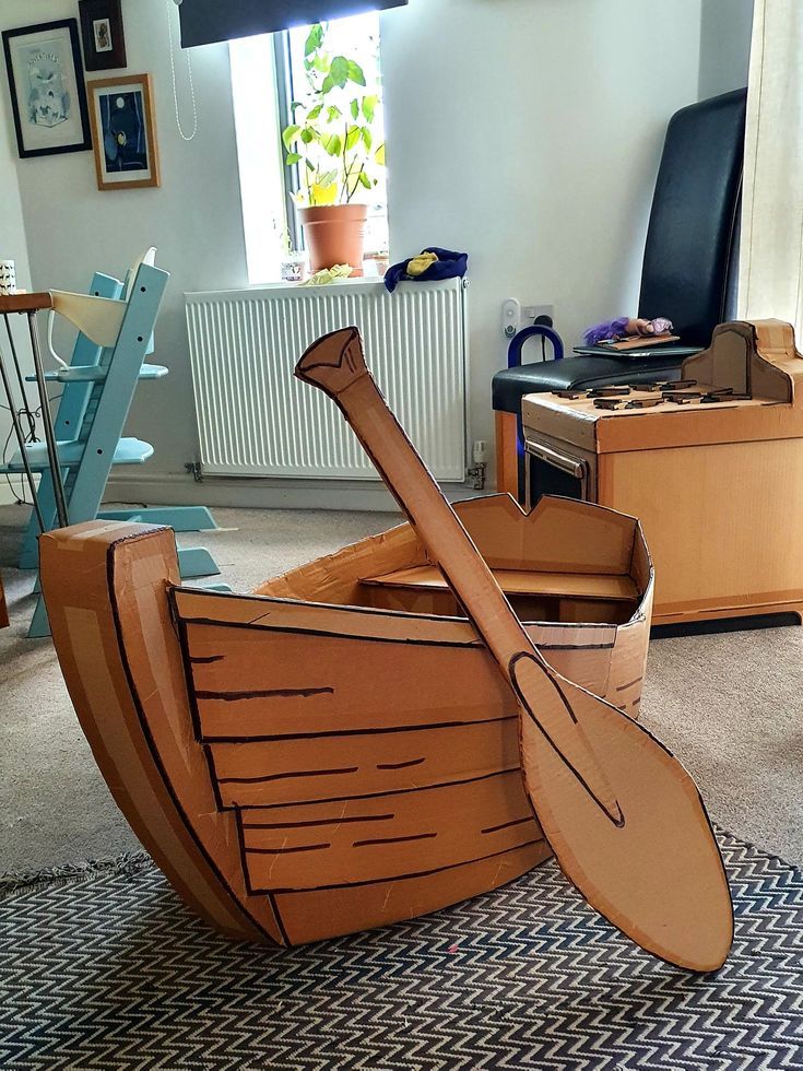 a cardboard boat sitting on top of a rug