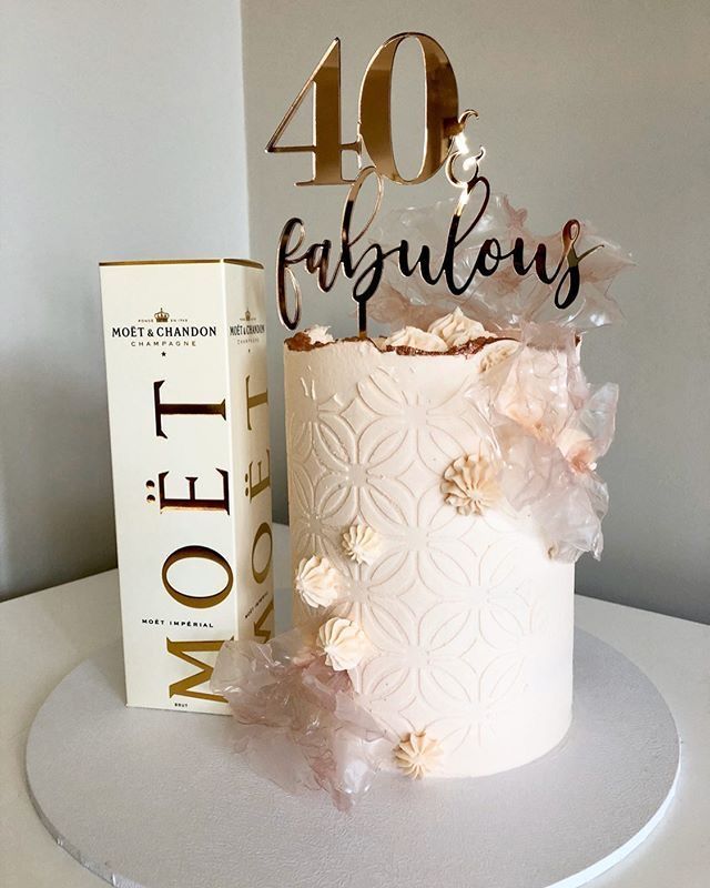 a white cake sitting on top of a table next to a box and a sign