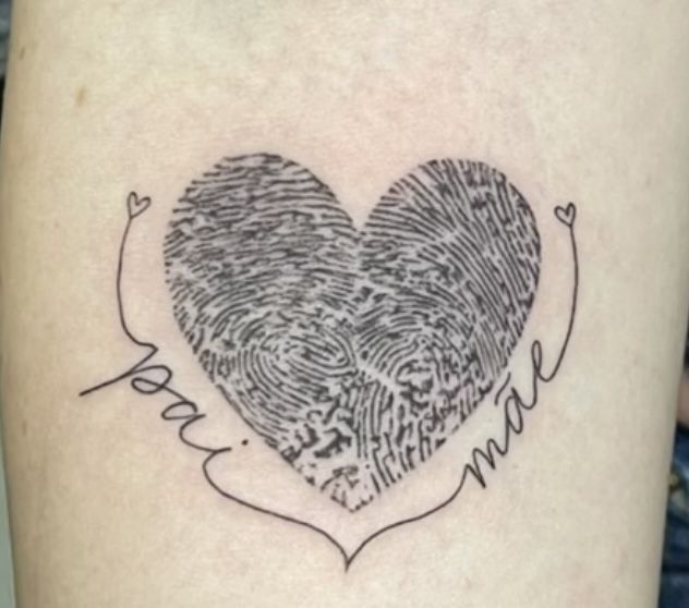 a heart shaped fingerprint tattoo on the thigh