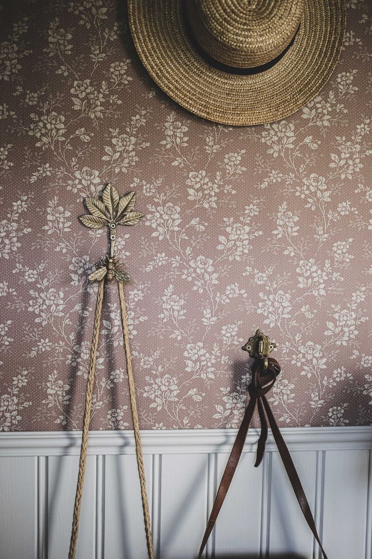 a hat is hanging on the wall next to a pair of old fashioned wooden tripods